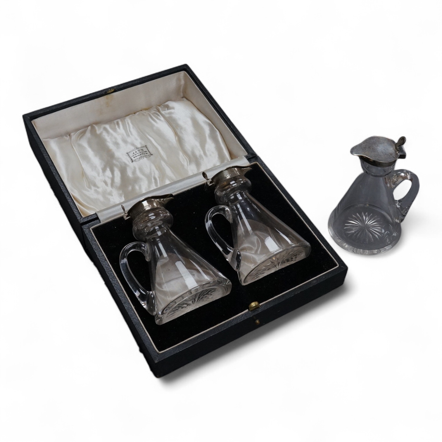 A cased pair of George V silver mounted glass whisky noggins, by S. Blanckensee & Sons, Birmingham, 1935, height 10.5cm, together with one other earlier whisky noggin, Hukin & Heath, Birmingham, 1908.